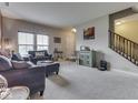 Open-concept living room with neutral decor, plush seating, and staircase access at 1232 Blue Haven Way, Greenwood, IN 46143