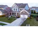 Attractive two-story home with a brick and vinyl exterior, covered porch with porch swing and landscaping at 14059 Knightstown E Dr, Carmel, IN 46033