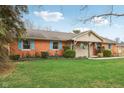 Single-story brick home features colorful shutters, landscaped yard, and covered entryway at 1526 Chapman Dr, Greenfield, IN 46140