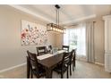 Elegant dining room with coffered ceiling, modern lighting, and a large window with natural light at 1559 Redsunset Dr, Brownsburg, IN 46112