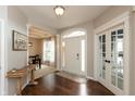 Bright foyer with hardwood floors, a glass door leading to an office, and view into the dining room at 1559 Redsunset Dr, Brownsburg, IN 46112