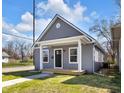 Charming home featuring a covered front porch, gray siding, and a well-manicured lawn, creating a welcoming curb appeal at 2041 N Dexter St, Indianapolis, IN 46202