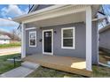 Charming home featuring a covered front porch, gray siding, and a well-manicured lawn, creating a welcoming curb appeal at 2041 N Dexter St, Indianapolis, IN 46202