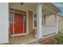 Welcoming front porch with a bright red door, white columns, and decorative accents at 2889 Grimes Way, Columbus, IN 47201