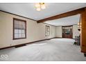 Spacious living room with neutral carpet, wood trim, fireplace, and large windows, perfect for relaxation and entertaining at 4711 Cornelius Ave, Indianapolis, IN 46208