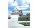 Traditional two-story home with a two-car garage, features a well-maintained lawn and classic black shutters at 5115 Triple Crown Way, Indianapolis, IN 46237