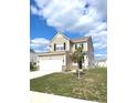 Attractive two-story home with a two-car garage, showcasing a manicured lawn and a young tree at 5115 Triple Crown Way, Indianapolis, IN 46237
