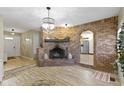 Cozy living room featuring a brick fireplace, chandelier, and wood-look floors at 5344 Tincher Rd, Indianapolis, IN 46221