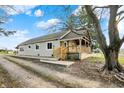 Cozy home featuring a quaint covered porch, complemented by a well-maintained lawn and mature trees at 5442 W 400 N, Fairland, IN 46126
