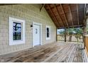 Covered porch showing wood flooring and ceiling, plus natural light, with a view of the surrounding greenery at 5442 W 400 N, Fairland, IN 46126
