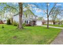 Landscaped front yard, two-story home with double-hung windows and a two-car garage with new grass at 594 N Shore Blvd, Franklin, IN 46131
