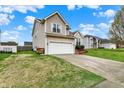Inviting two-story home with a two-car garage and landscaped front yard on a sunny day at 6064 Brandermill Rdg, Columbus, IN 47203