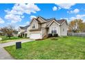 Traditional two-story home boasts manicured lawn and mature trees in a suburban neighborhood at 6064 Brandermill Rdg, Columbus, IN 47203