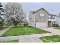 Charming home with a large tree, lush lawn, and a peek at a nearby park, creating an inviting curb appeal at 6518 Sonesta Dr, Indianapolis, IN 46217