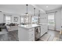 Open kitchen with a large island, seamlessly connected to the living and dining areas at 7391 Blandford Dr, Plainfield, IN 46168