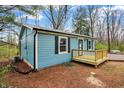 Side view of charming blue home with new deck, black shutters, metal roof and black gutters and downspouts at 7469 Lion Dr, Nineveh, IN 46164