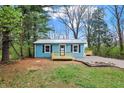 Charming blue home featuring a metal roof, dark shutters, and newly constructed wooden porches in a wooded lot at 7469 Lion Dr, Nineveh, IN 46164
