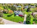 Aerial view of a white home with a well-manicured lawn surrounded by lush trees and neighborhood at 7531 Normandy Blvd, Indianapolis, IN 46278