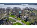 Aerial view of a neighborhood with lush green trees, lake, and beautiful homes at 9111 Sand Key Ln, Indianapolis, IN 46256