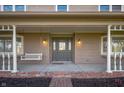 Charming front porch with swing, columns, brick foundation, and inviting entrance at 9111 Sand Key Ln, Indianapolis, IN 46256