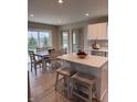 Bright eat-in kitchen featuring white cabinets, island with breakfast bar, and stainless steel appliances at 99 Gnarled Oak Ln, Whiteland, IN 46184