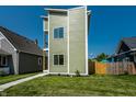 Modern three-story home with vibrant green siding complemented by bright white trim and a well-manicured lawn at 1038 St Peter St, Indianapolis, IN 46203