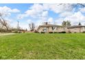 Lovely single-story home with stone exterior and a well-maintained front lawn under a blue sky at 1061 N Layman Ave, Indianapolis, IN 46219