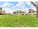 Charming stone home features a well-manicured lawn, mature trees, and a welcoming facade at 1061 N Layman Ave, Indianapolis, IN 46219