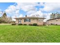 Stone home with a well-kept lawn showcases its classic charm and welcoming curb appeal at 1061 N Layman Ave, Indianapolis, IN 46219