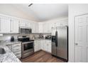Modern kitchen features stainless steel appliances, granite countertops, and white cabinets at 10799 Belair Dr, Carmel, IN 46280
