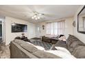 Comfortable living room with large sofa, ceiling fan, and door to front yard at 11416 Stoeppelwerth Dr, Indianapolis, IN 46229