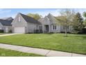Charming single-story home with a large front lawn, a two-car garage and a welcoming entryway at 11930 Pebblepointe Pass, Carmel, IN 46033