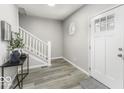 Bright entryway featuring hardwood floors, staircase and stylish decor, providing a welcoming ambiance at 126 S 3Rd Ave, Beech Grove, IN 46107