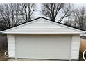 A single-car garage featuring a white door with paneled design and matching white siding at 1311 N Denny St, Indianapolis, IN 46201