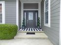 Inviting front entrance with sidelights, decorative plants, and stylish welcome mat at 13151 Walters Rd, Martinsville, IN 46151