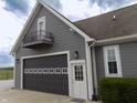 Home exterior featuring attached garage, small balcony and adjacent green shrubbery at 13151 Walters Rd, Martinsville, IN 46151