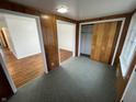 View of a room with hardwood and tile flooring, wood paneled walls, and closet at 1509 N Mann Ave, Muncie, IN 47304