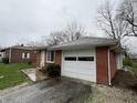 Side view of brick house with garage and yard on an overcast day at 1509 N Mann Ave, Muncie, IN 47304