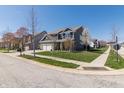 Charming two-story home with a well-manicured lawn, brick accents, and a three car garage at 15493 Kennewick, Noblesville, IN 46062