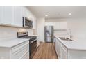 Modern kitchen featuring stainless steel appliances, quartz countertops, white cabinets and hardwood flooring at 18769 Moray St, Westfield, IN 46074