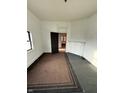 Empty room with carpet flooring, white walls, fireplace and open door at 2338 N Harding St, Indianapolis, IN 46208