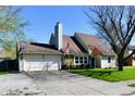 Inviting single-Gathering home with an attached garage, mature trees, and front-yard American flag at 260 Christina Dr, Whiteland, IN 46184