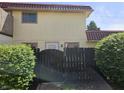 Charming townhome featuring tan siding, a brown tile roof and enclosed by a decorative black fence at 2804 Paso Del Norte Dr, Indianapolis, IN 46227