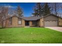 Charming single-story home featuring a stone facade, attached garage, and well-manicured front yard at 3037 Santiago Dr, Greenwood, IN 46143