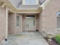 Welcoming front entrance of brick home, featuring stone walkway, neutral door, and manicured landscaping at 443 Mclaren Ln, Carmel, IN 46032