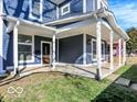 Inviting covered porch with sturdy white columns, dark blue siding, and well-maintained green lawn at 46 N Denny St, Indianapolis, IN 46201