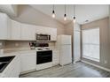 Bright kitchen featuring white cabinets, modern appliances, and pendant lighting at 5541 Fair Ridge Pl, Indianapolis, IN 46221