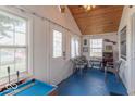 Cozy sun room with multiple windows, blue floor, and small pool table at 555 Leeds Ave, Indianapolis, IN 46203