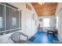Bright sun room with wood ceiling, blue floors, and ample light from large windows at 555 Leeds Ave, Indianapolis, IN 46203