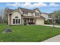 Traditional two-story home with manicured lawn, red window trim, and attached garage, great for families at 5710 Dapple Trce, Indianapolis, IN 46228